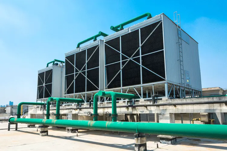A cooling tower HVAC system sits atop a data center during a clear sky day.